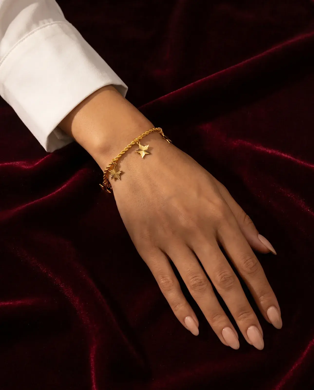 A model wearing the Twisted Chain Star Bracelet in 21K yellow gold