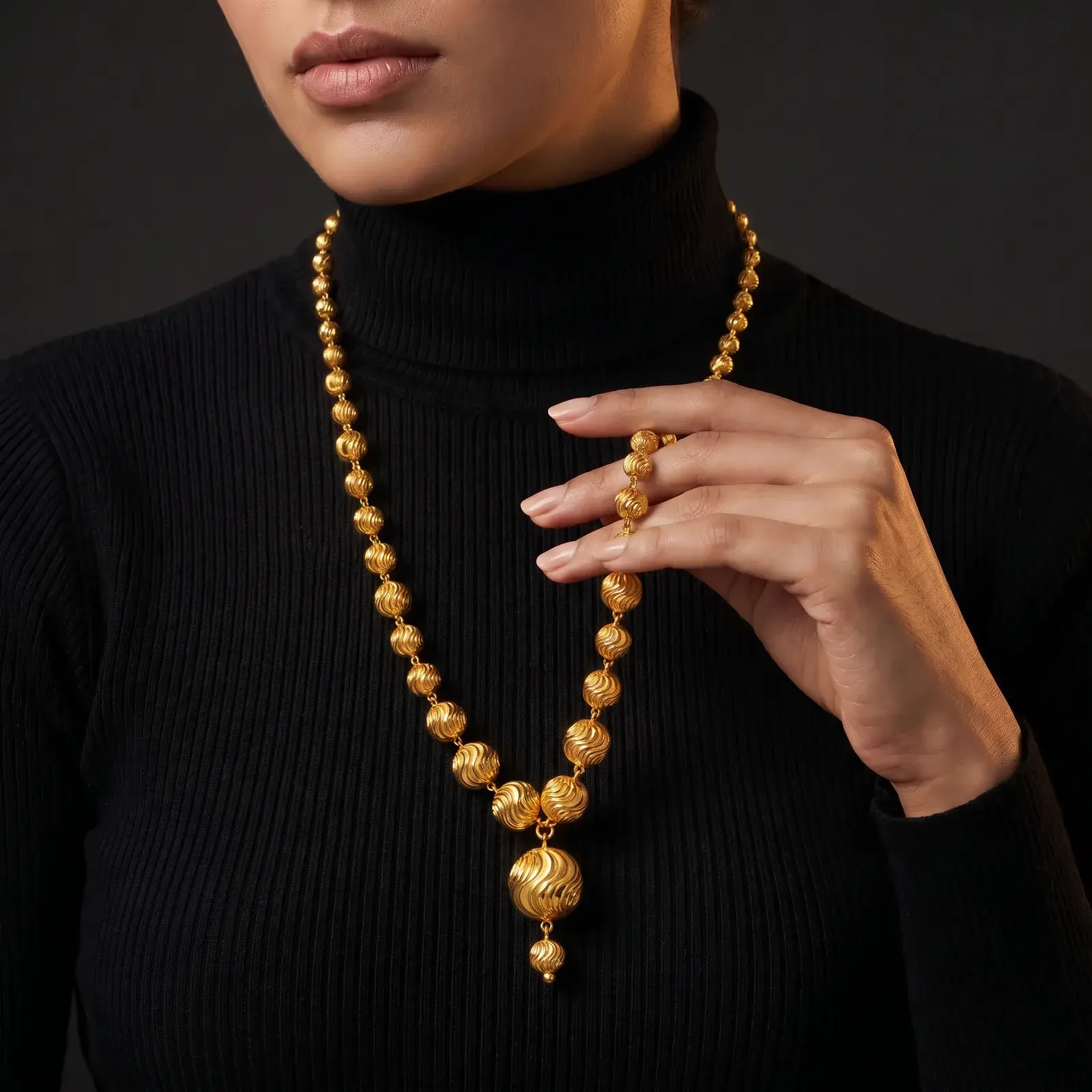 A model wearing the Malaysian Rosary Necklace in 21K yellow gold