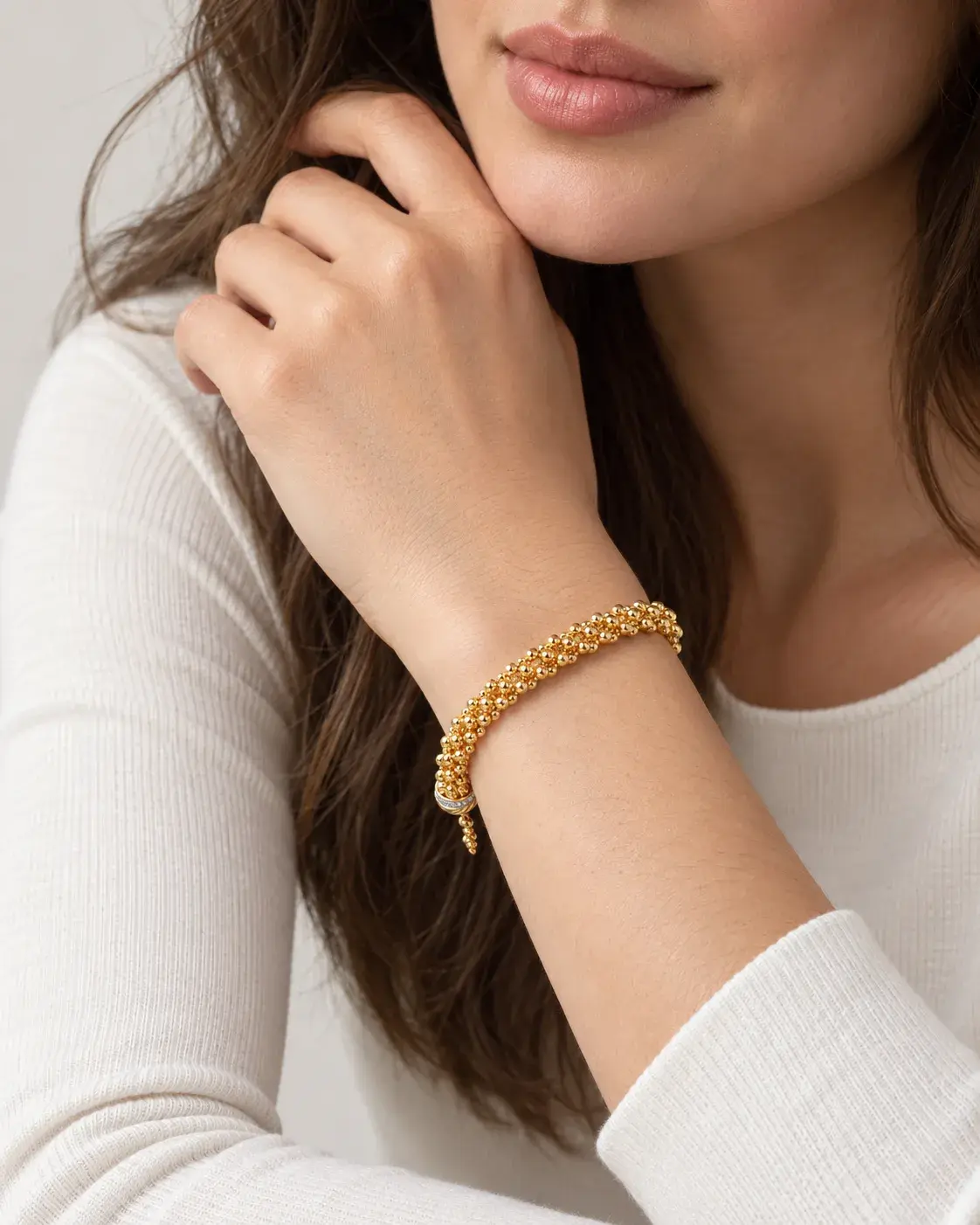 A model wearing the Ball Beaded Chain Bracelet in 21K yellow gold